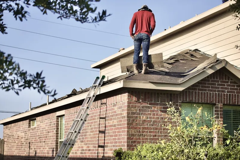 Professional roofer working on a residential roof in Medical Center